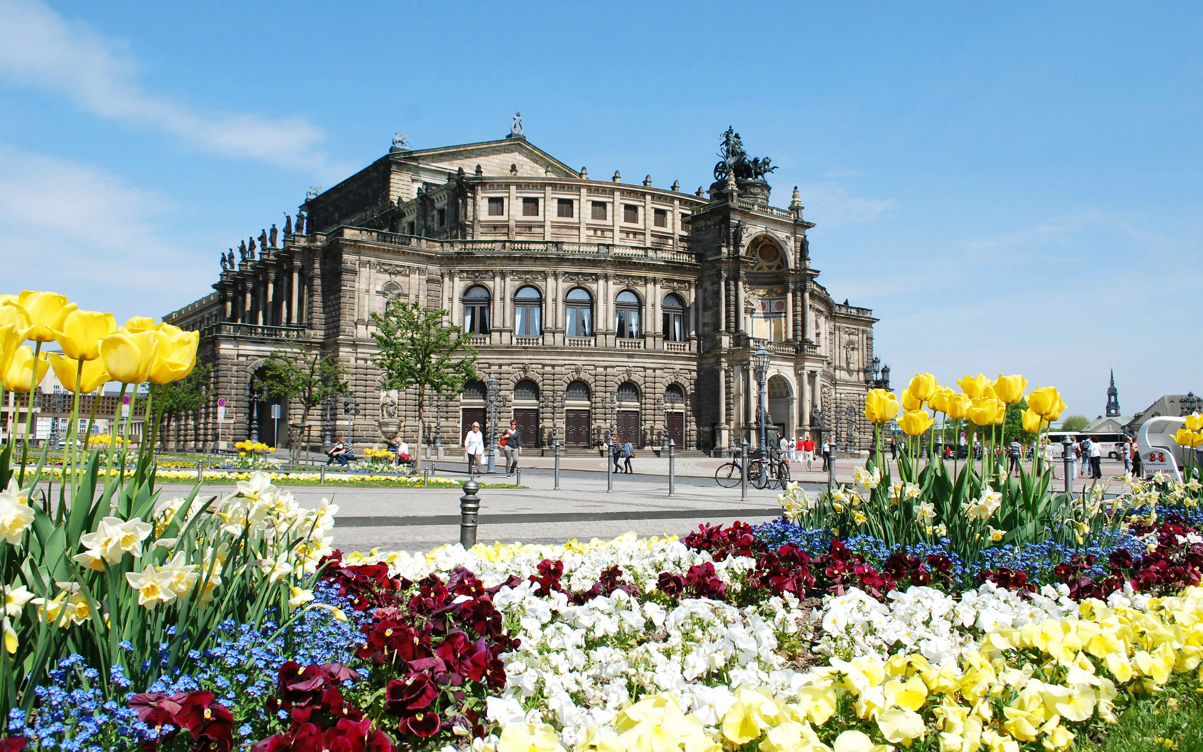 Semperoper Dresden with colorful flower garden in foreground during Altstadtrundgang tour.