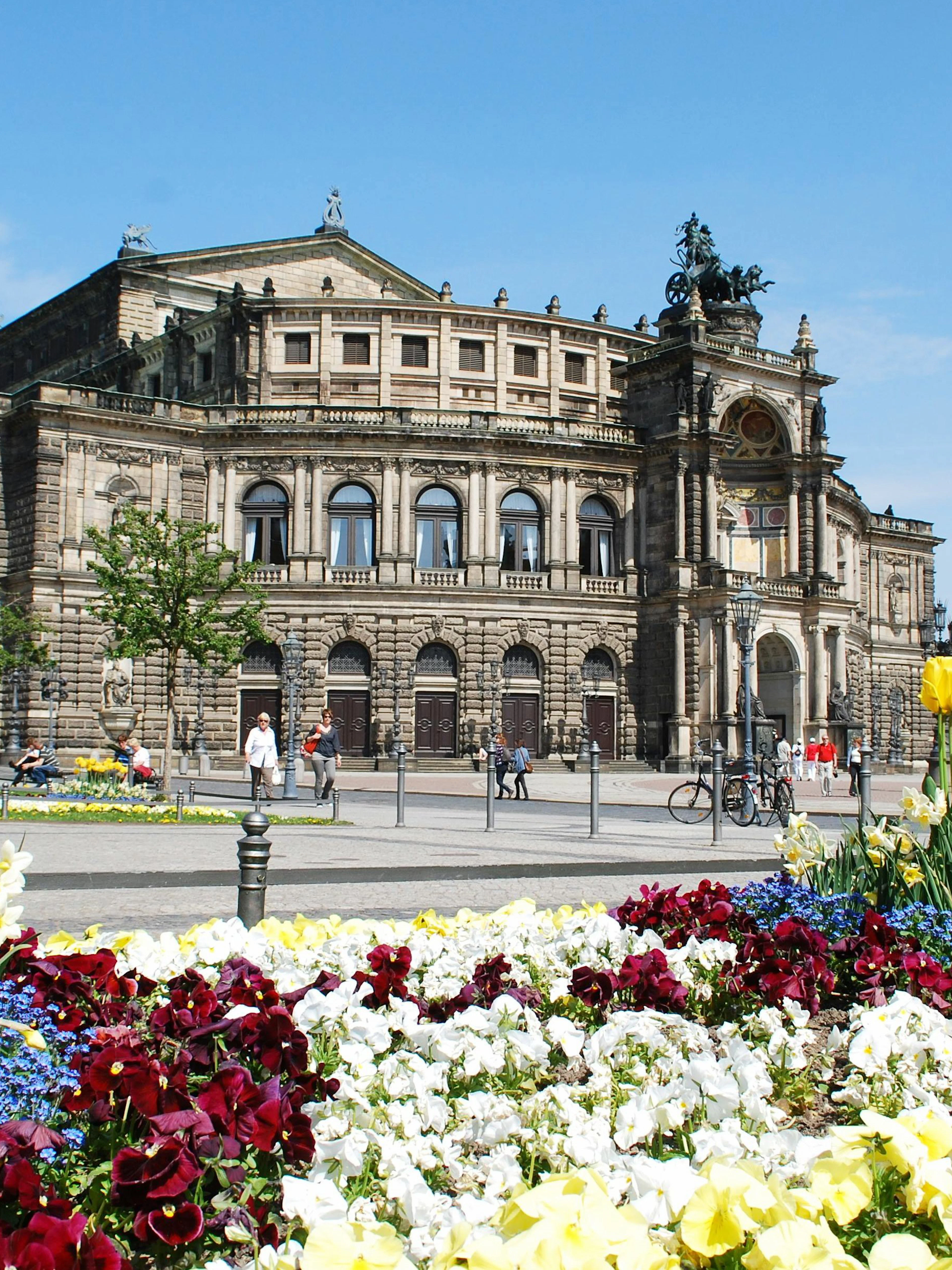 Semperoper Dresden with colorful flower garden in foreground during Altstadtrundgang tour.