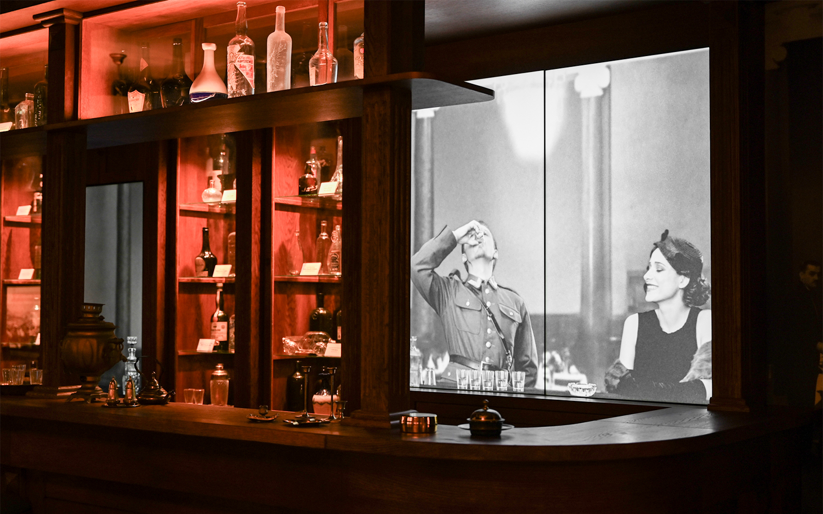 Vodka bottles displayed at Krakow Vodka Factory Museum with historical photo backdrop.