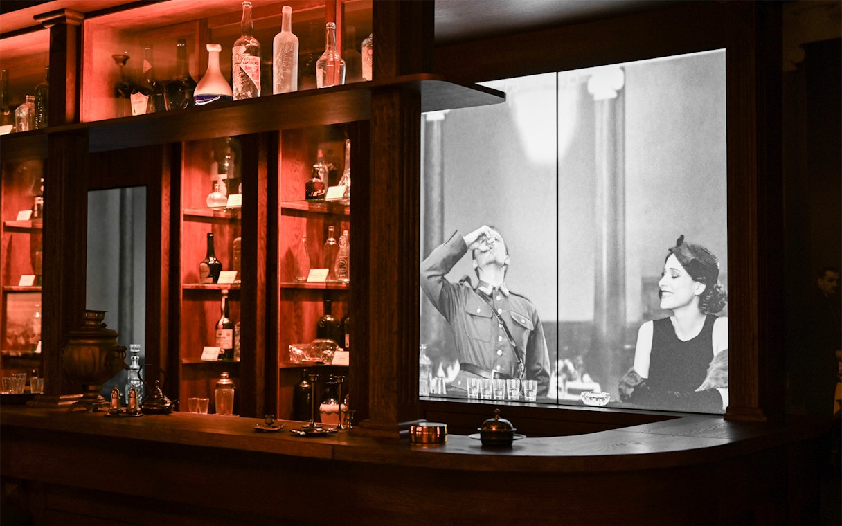 Vodka bottles displayed at Krakow Vodka Factory Museum with historical photo backdrop.