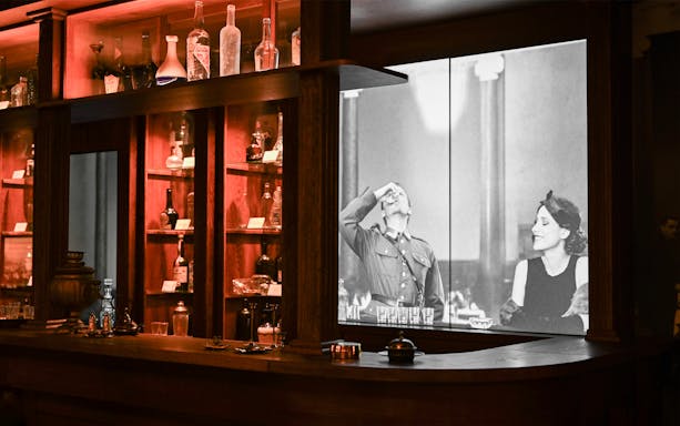 Vodka bottles displayed at Krakow Vodka Factory Museum with historical photo backdrop.