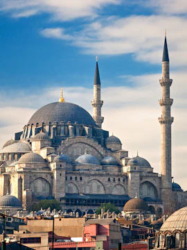 Süleymaniye Mosque with its domes and minarets under a blue sky in Istanbul.