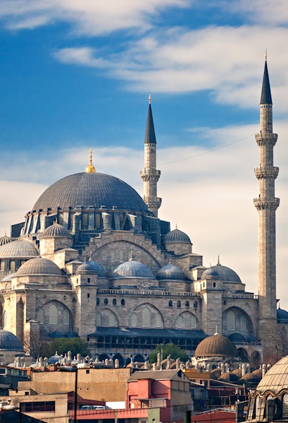 Süleymaniye Mosque with its domes and minarets under a blue sky in Istanbul.