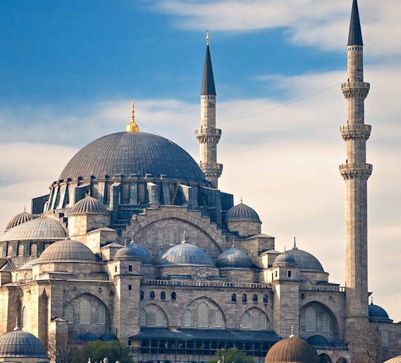 Süleymaniye Mosque with its domes and minarets under a blue sky in Istanbul.