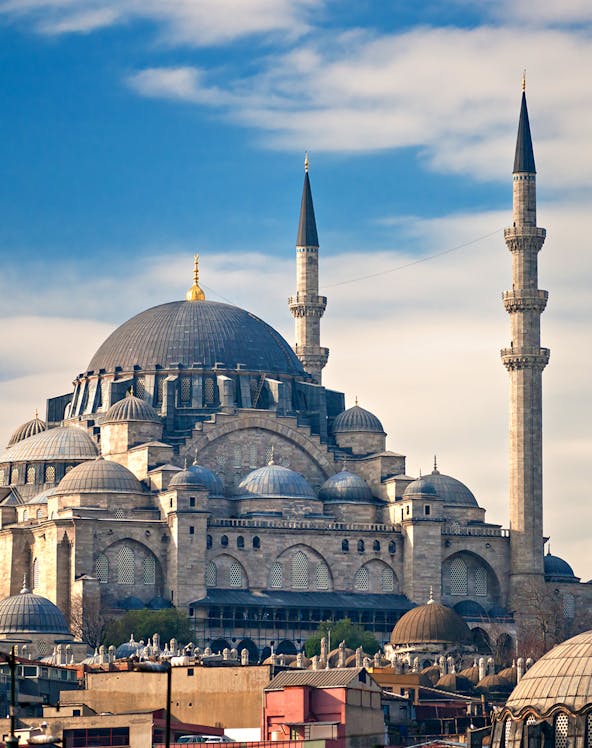 Süleymaniye Mosque with its domes and minarets under a blue sky in Istanbul.