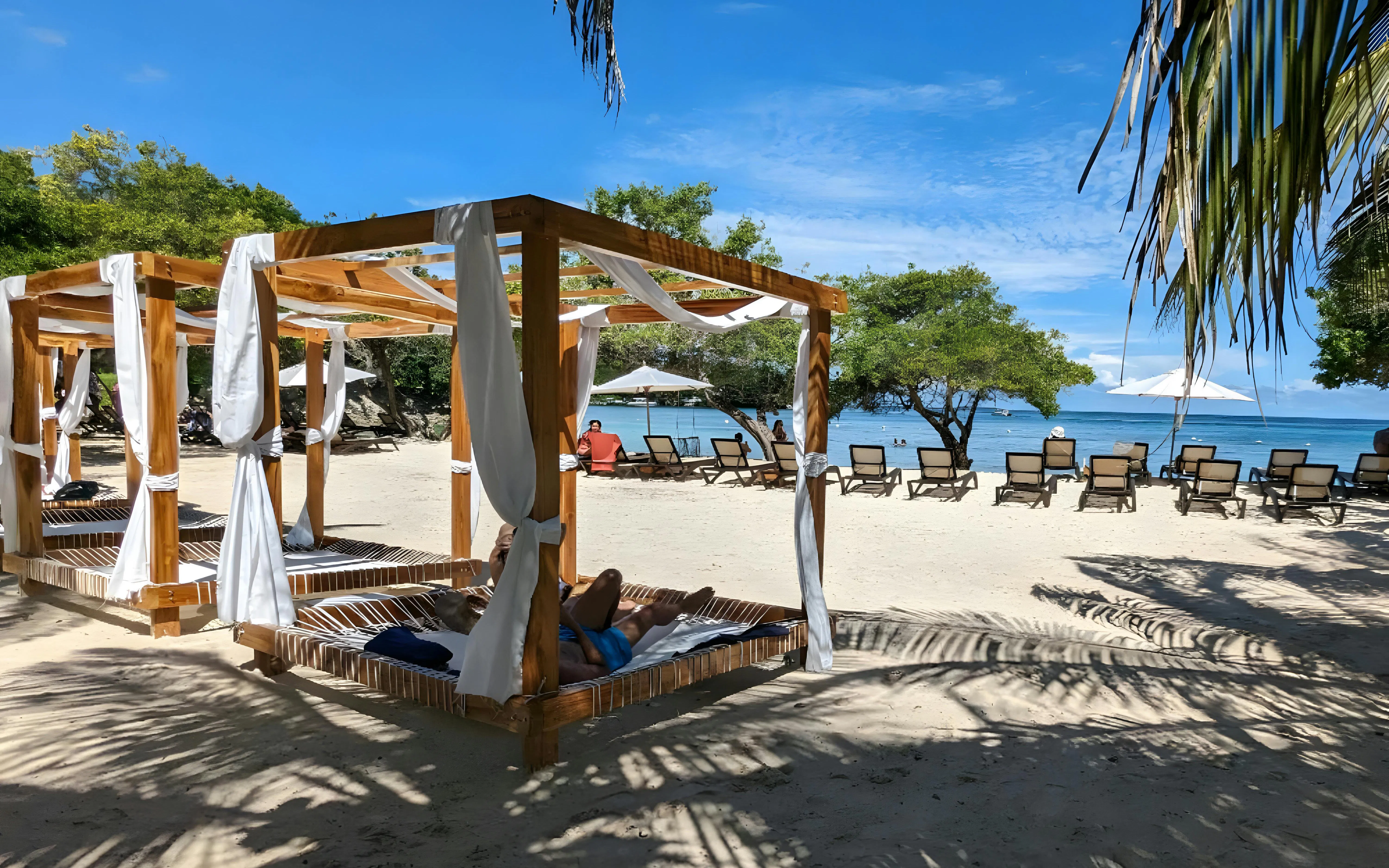Tourist relaxing on a beach bed under a canopy at Rosario Islands, near Cartagena, Colombia.