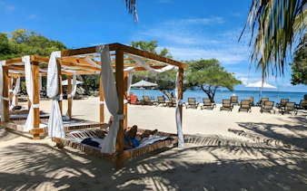 Tourist relaxing on a beach bed under a canopy at Rosario Islands, near Cartagena, Colombia.