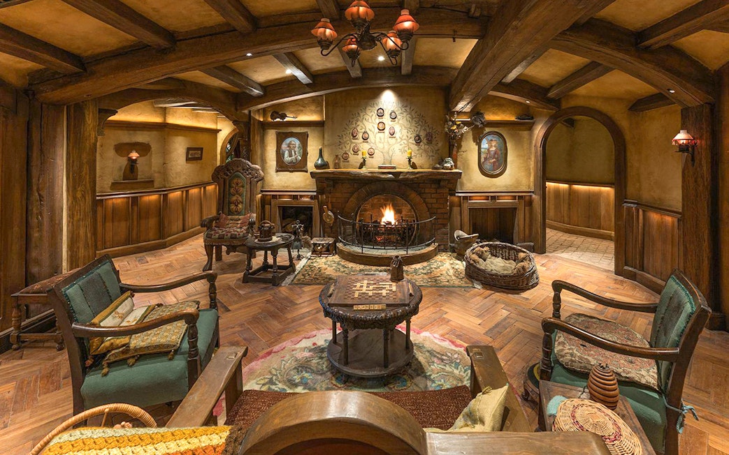 Cozy seating area with fireplace and hobbit-themed decor at Green Dragon Inn, Hobbiton Movie Set.
