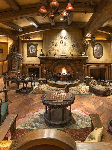 Cozy seating area with fireplace and hobbit-themed decor at Green Dragon Inn, Hobbiton Movie Set.
