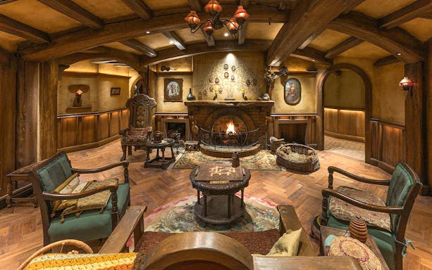 Cozy seating area with fireplace and hobbit-themed decor at Green Dragon Inn, Hobbiton Movie Set.