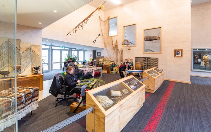 Craftsmen weaving flax at Te Puia cultural center, Rotorua, New Zealand.
