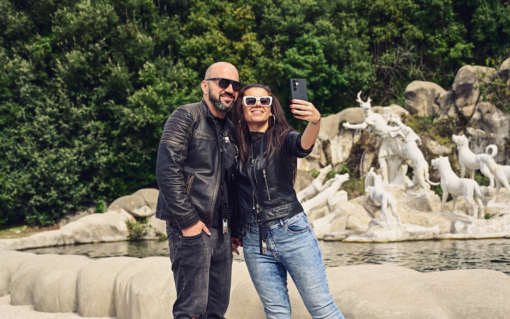Tourists taking a selfie at the Royal Palace of Caserta fountains, Italy.