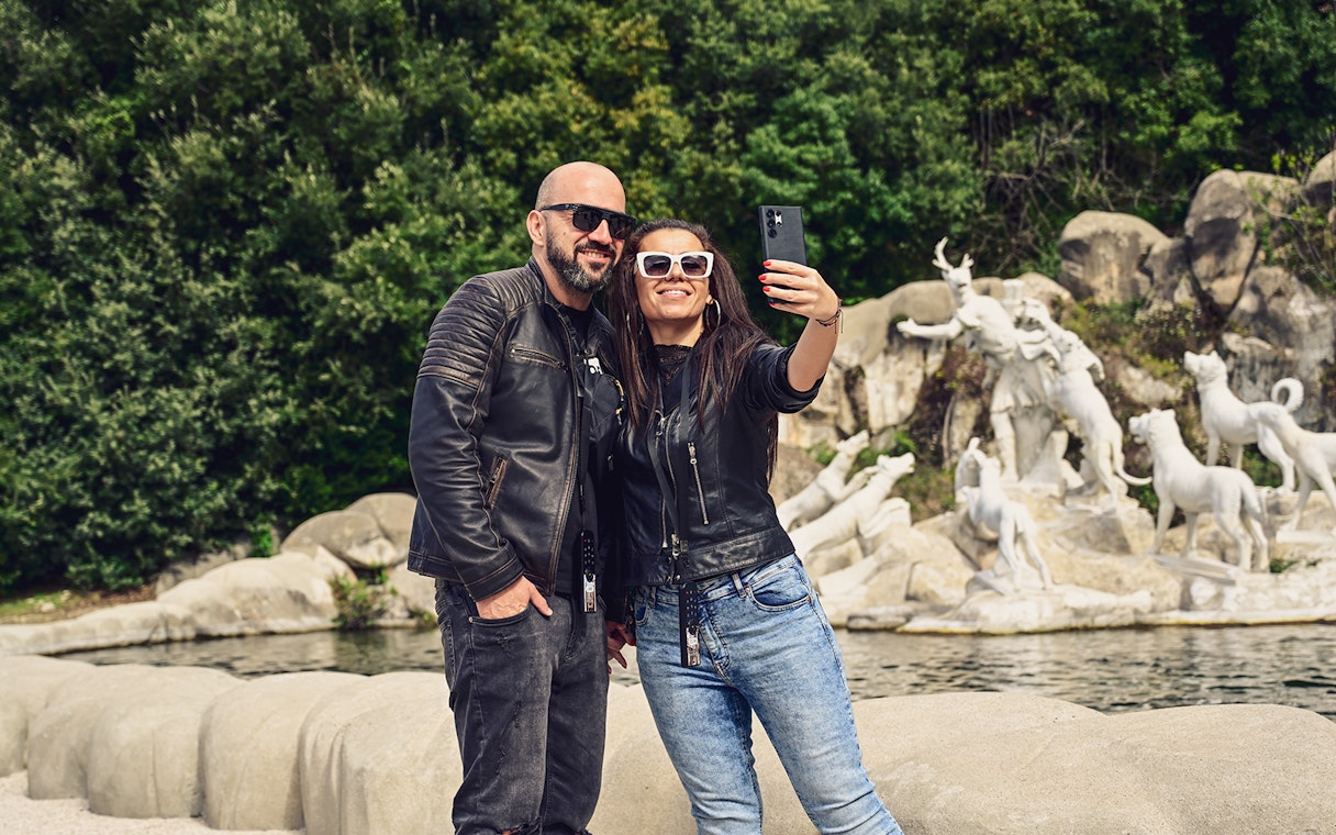 Tourists taking a selfie at the Royal Palace of Caserta fountains, Italy.