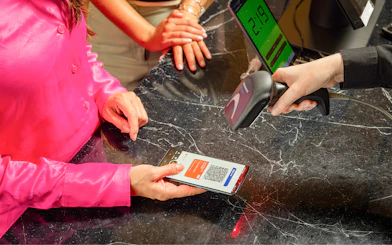 Couple scanning I Amsterdam City Card at a store counter.