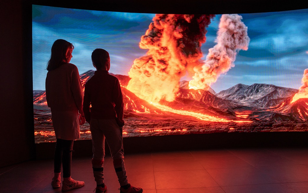 Children viewing volcanic eruption display at Espai Crater exhibit.
