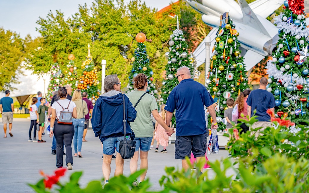 Visitors walking among decorated trees at Kennedy Space Center, Florida.
