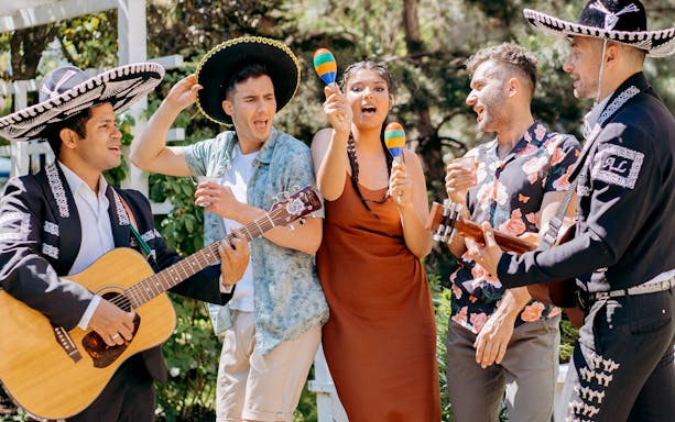 Mariachi band playing music with people enjoying maracas during a Mexico City night tour.