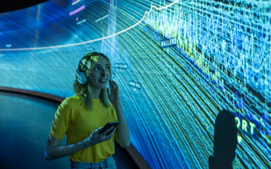 Visitor using audio guide inside Glories Skyline Tower exhibition.