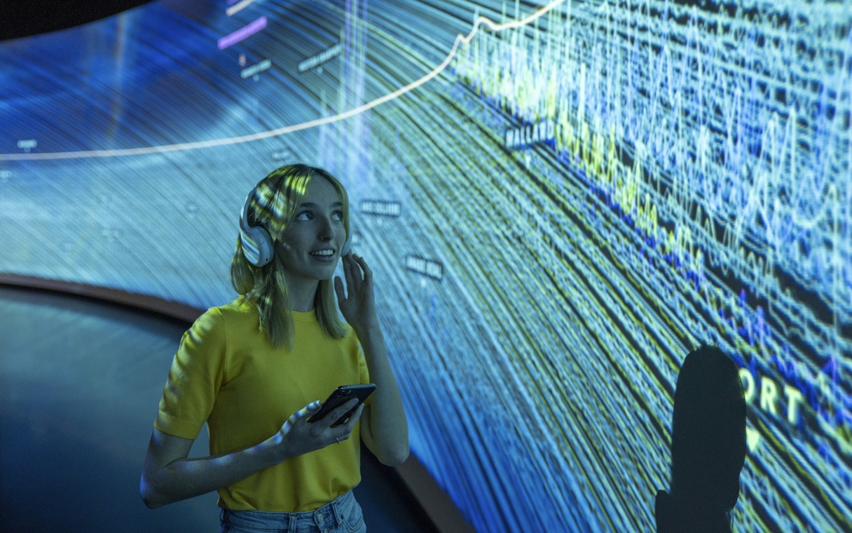 Visitor using audio guide inside Glories Skyline Tower exhibition.