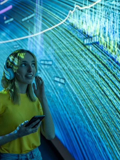 Visitor using audio guide inside Glories Skyline Tower exhibition.