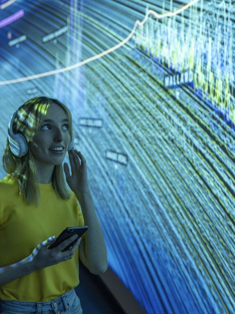 Visitor using audio guide inside Glories Skyline Tower exhibition.