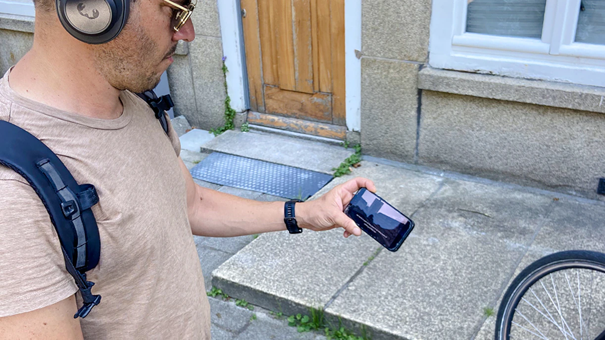 Guest using phone during Anne Frank walk in Amsterdam.