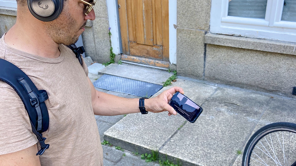 Guest using phone during Anne Frank walk in Amsterdam.