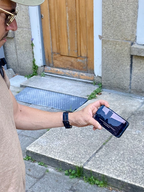Guest using phone during Anne Frank walk in Amsterdam.