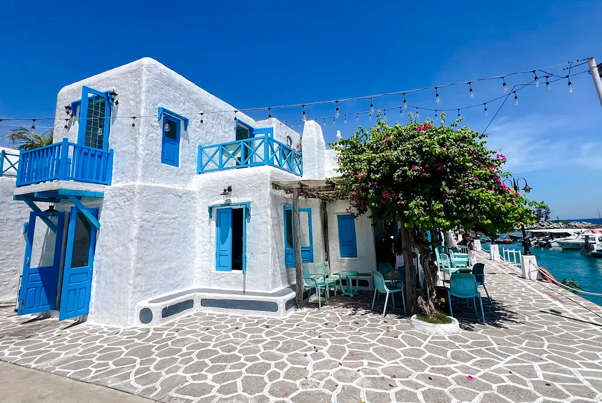 White building with blue accents by the sea, part of Da Nang Coastal Charm Half-Day Cafe Tour.