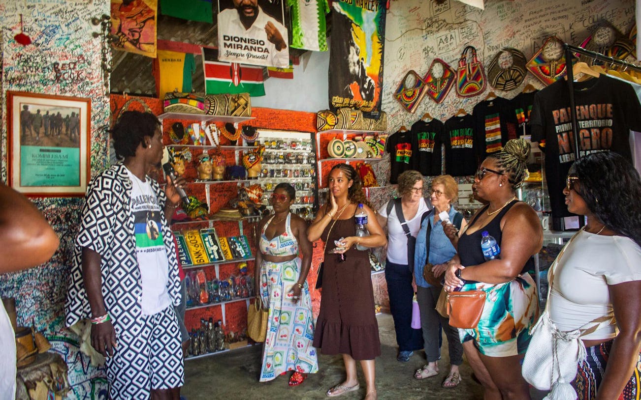 Visitors with a local guide inside a colorful museum in San Basilio de Palenque.