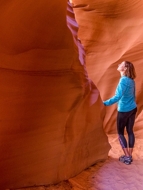 Young woman exploring the sandstone formations of Antelope Canyon, Arizona.