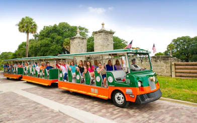 Old Town Trolley with tourists near City Gate, St. Augustine.