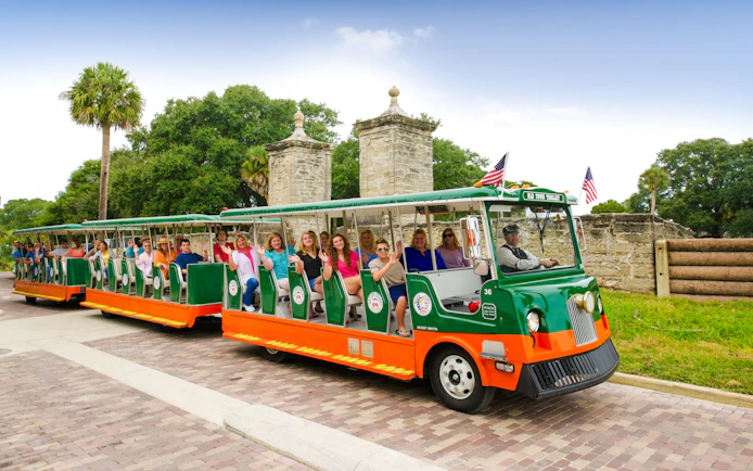 Old Town Trolley with tourists near City Gate, St. Augustine.