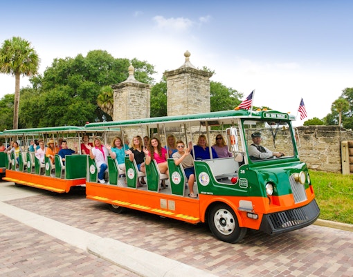 Old Town Trolley with tourists near City Gate, St. Augustine.