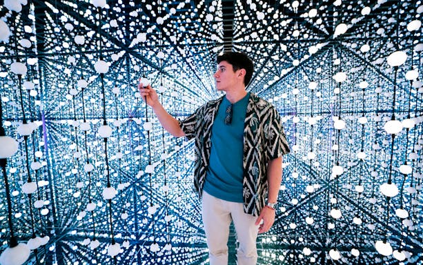 Visitor interacting with Bubble Planet light installation in Singapore.