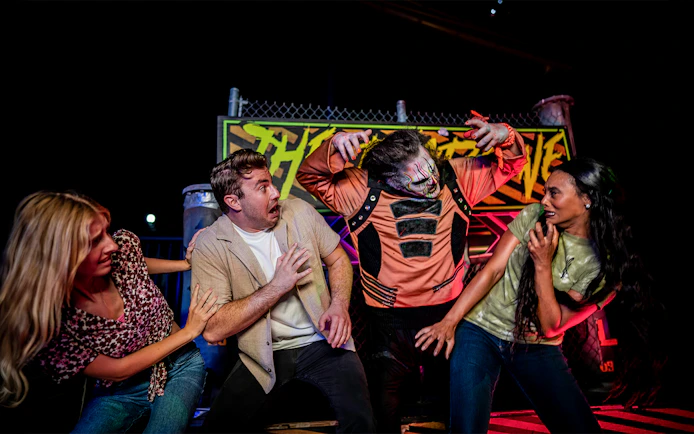 Visitors react to a costumed performer in the SCarowinds Maze at Six Flags Snicker's Halloween Event.
