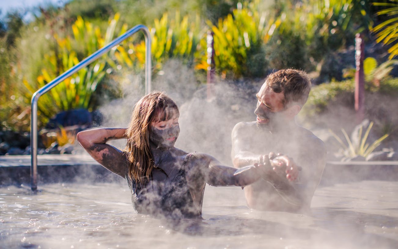 Couple enjoying a mud bath at Hell's Gate geothermal park.