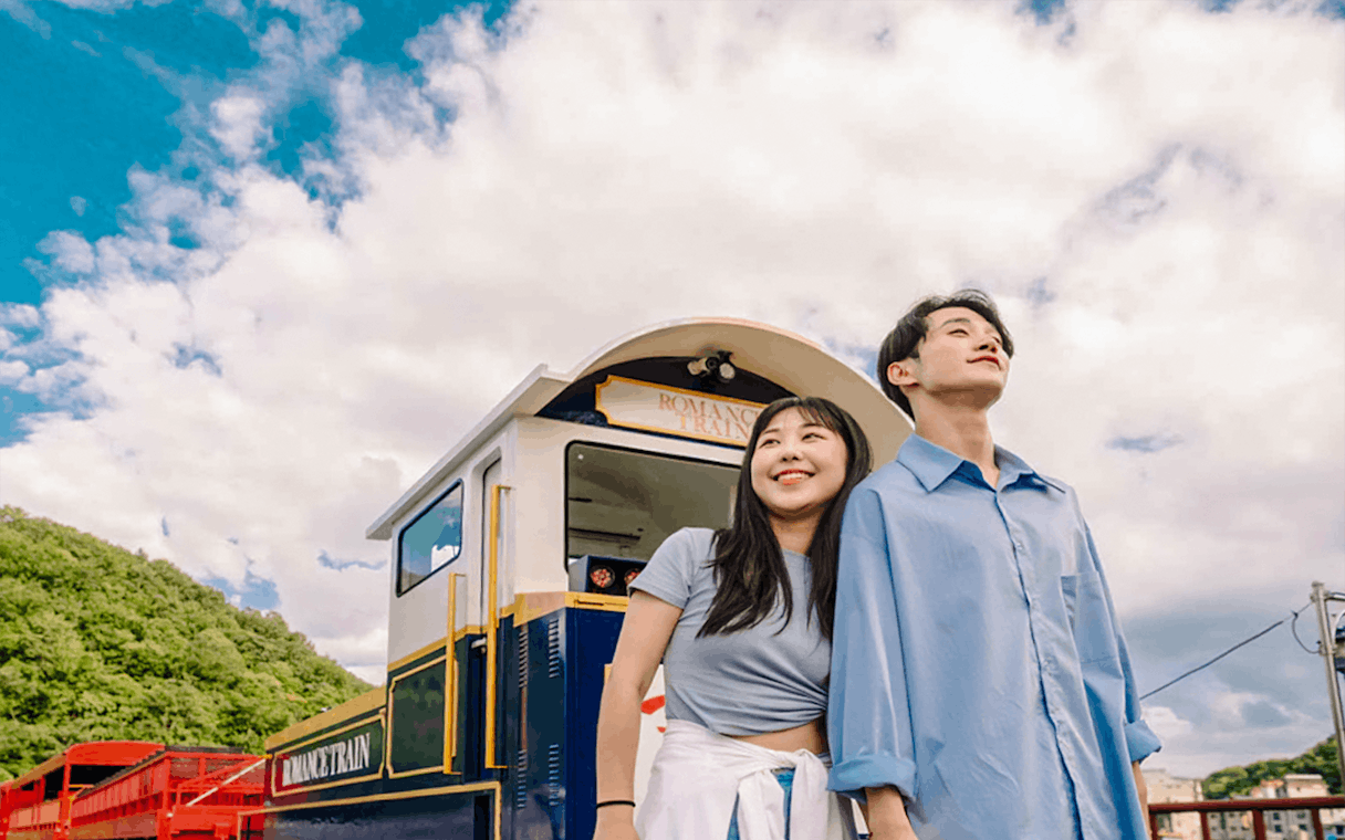 Couple enjoying Gangchon Gimnyujeong Rail Bike ride with scenic view.