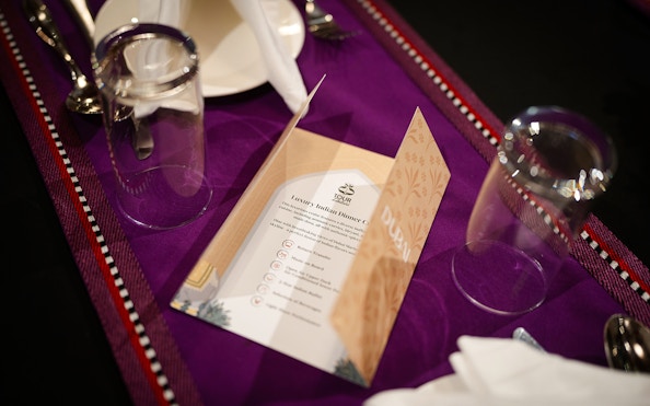 Menu on table setting for Dubai Marina Dhow Cruise with Indian dinner.
