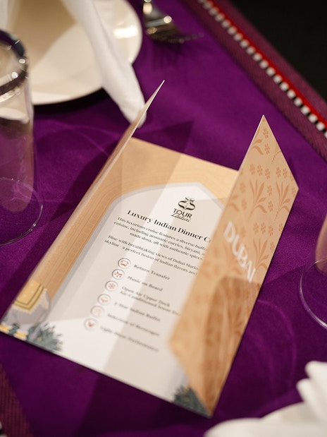 Menu on table setting for Dubai Marina Dhow Cruise with Indian dinner.