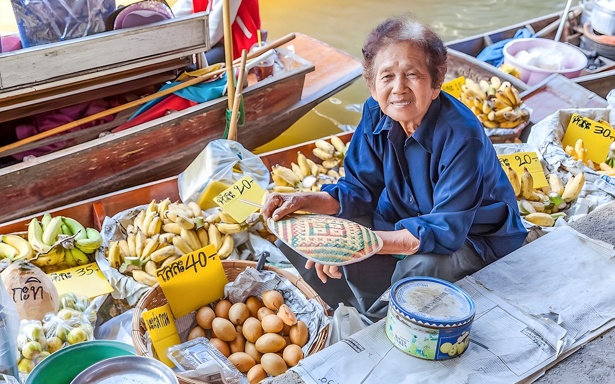 Vendor selling bananas and eggs at Damnoen Saduak Floating Market, Thailand.