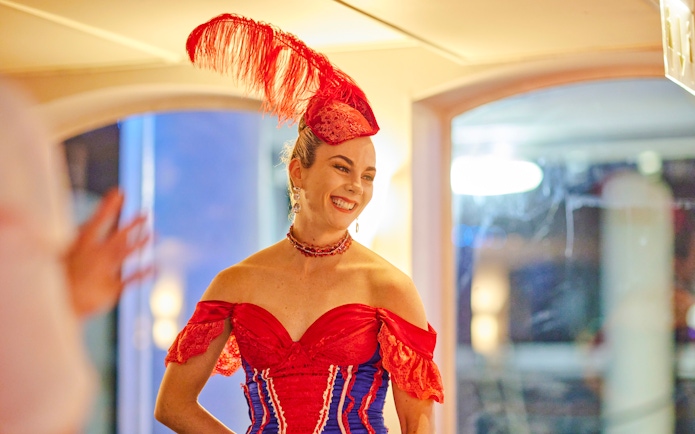 Performer in red costume on Showboat Vivid Sydney dinner cruise.