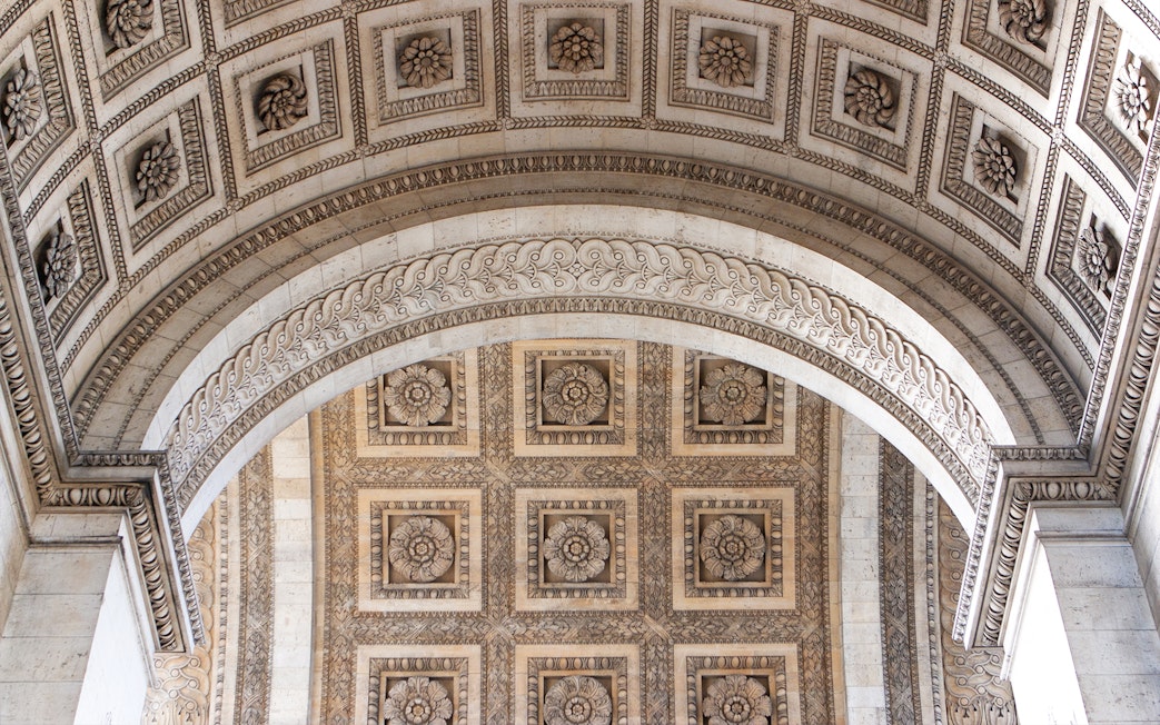 Ornate ceiling detail of the Arc de Triomphe in Paris, featuring intricate floral carvings.