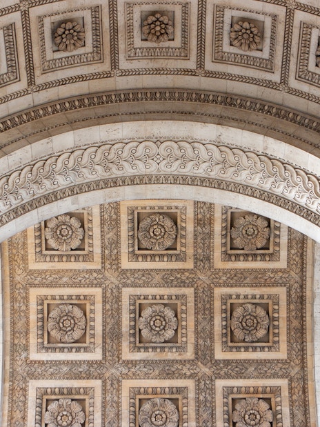 Ornate ceiling detail of the Arc de Triomphe in Paris, featuring intricate floral carvings.