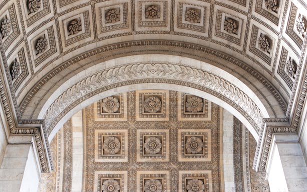 Ornate ceiling detail of the Arc de Triomphe in Paris, featuring intricate floral carvings.