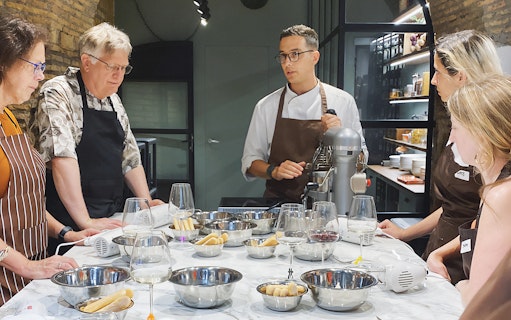 Cooking class participants learning to make ravioli and tiramisu near the Colosseum.