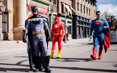 Batman, The Flash, and Superman walking in DC Super Heroes World at Parque Warner Madrid.