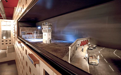 DDR Museum Berlin exhibit featuring Berlin Wall and guard tower model.