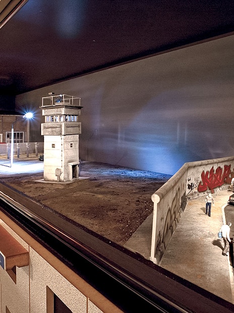 DDR Museum Berlin exhibit featuring Berlin Wall and guard tower model.