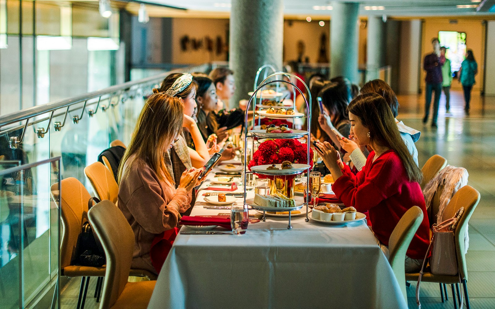 Guests enjoying high tea at National Gallery of Victoria with tiered trays of pastries.